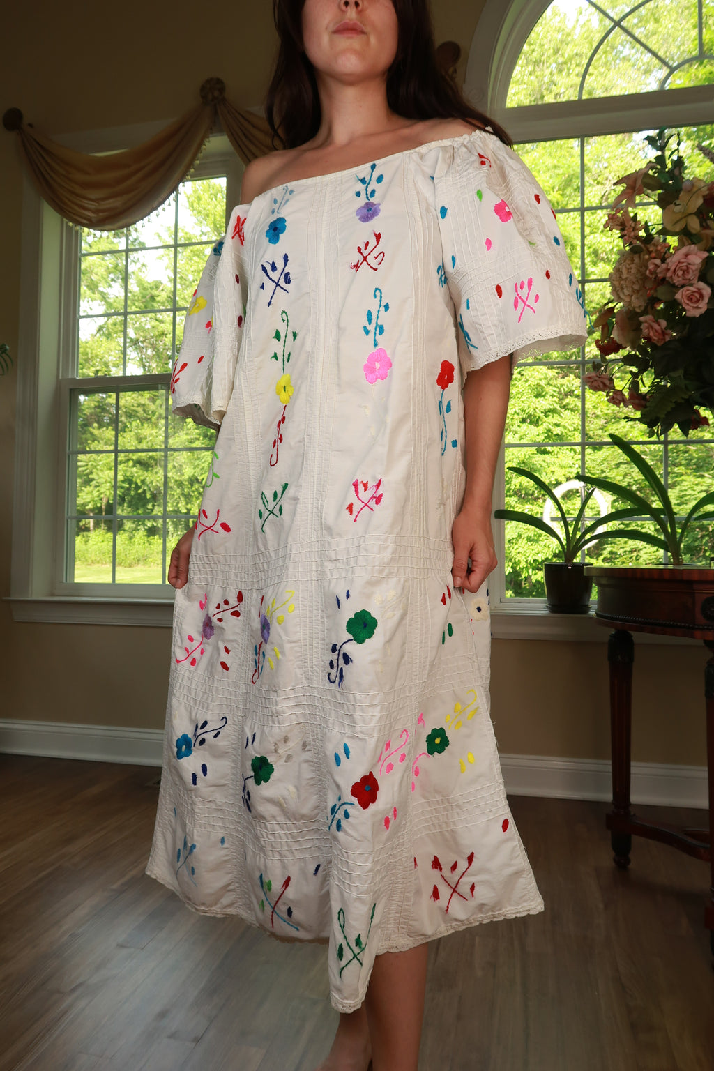 Vintage white off-shoulder embroidered peasant midi dress by Elektra Vintage, featuring intricate embroidery and flowing fabric.