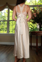 Load image into Gallery viewer, Elektra Vintage ivory satin empire waist maxi dress displayed on a hanger, showcasing elegant vintage style and flowing fabric.

