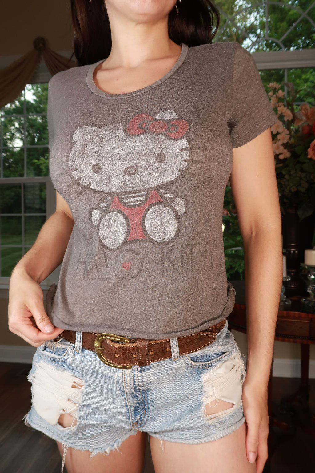 Vintage Hello Kitty graphic baby tee for women by Elektra Vintage, featuring a cute Hello Kitty design on soft fabric.