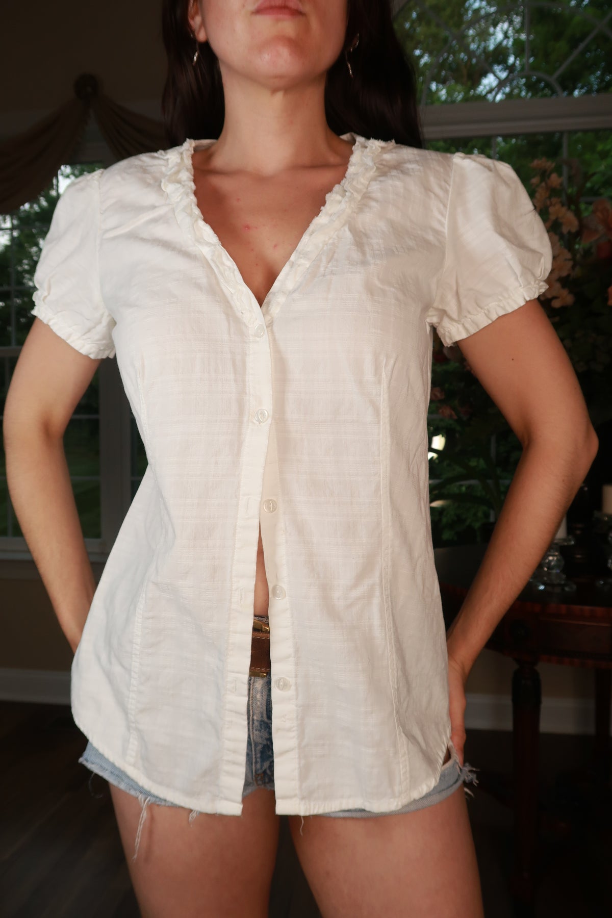 Vintage Calvin Klein white cotton puff sleeve blouse with button front, displayed on a hanger.