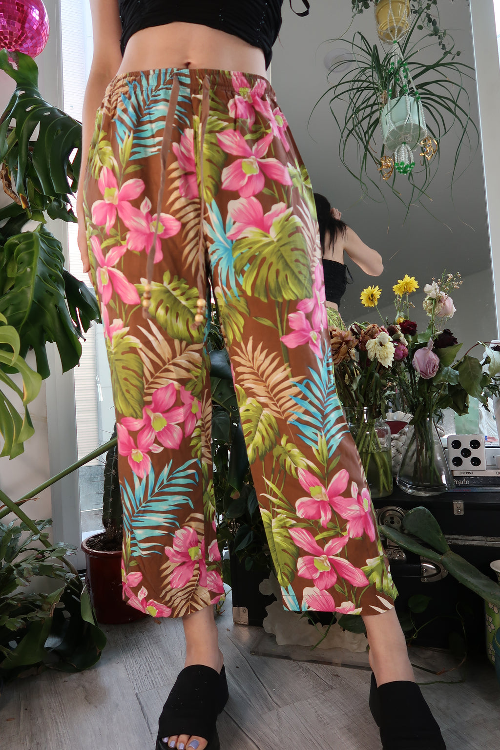 Women's vintage silk cropped trousers with tropical pattern and drawstring waist by Elektra Vintage, featuring vibrant floral details.