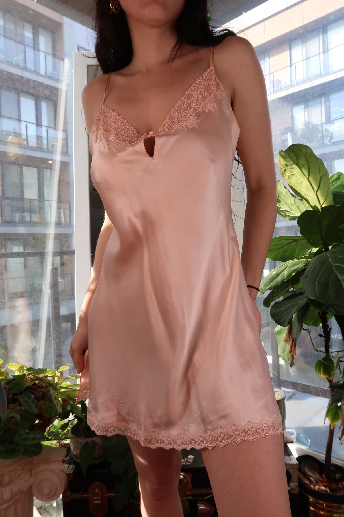 Vintage 2000s Victoria’s Secret peach silk slip dress with lace trim, styled by Elektra Vintage, hanging on a wooden hanger.