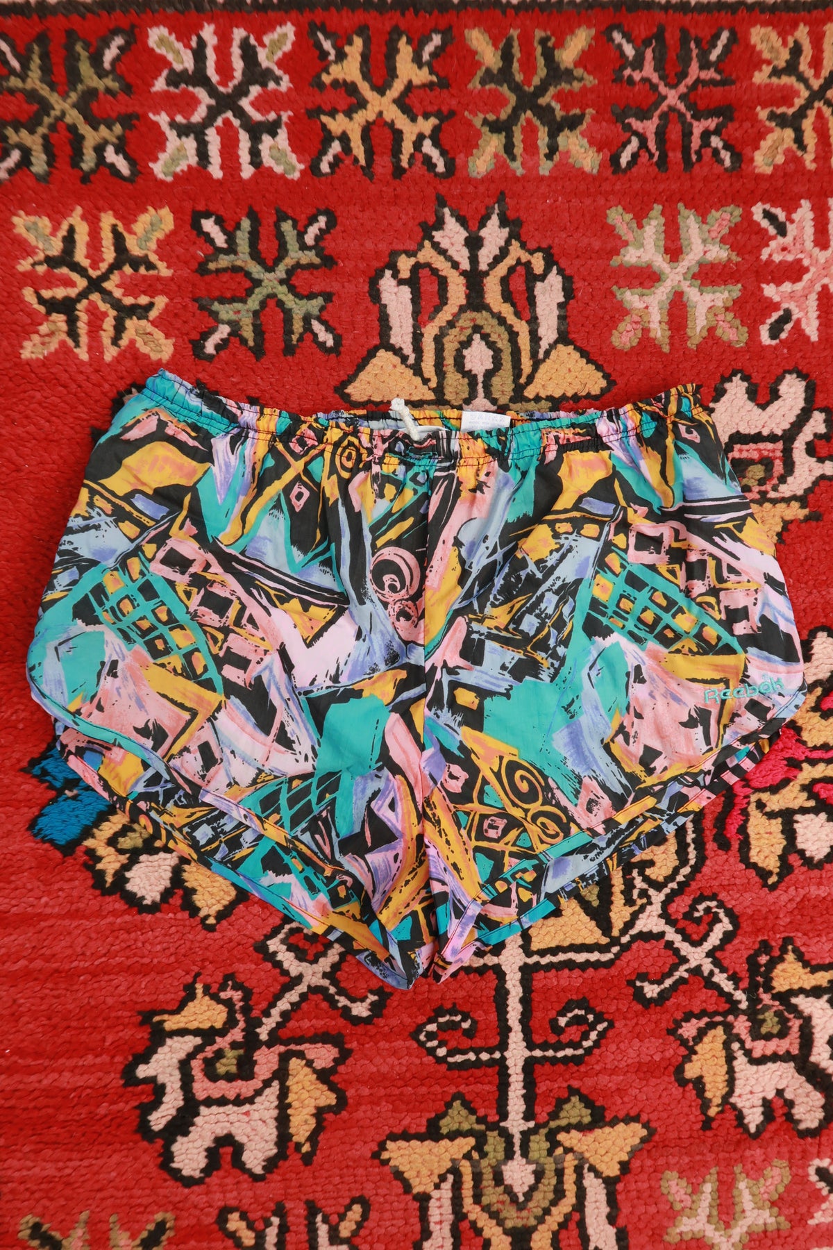 Vintage 90s Reebok abstract print women's running shorts with colorful geometric patterns from Elektra Vintage.