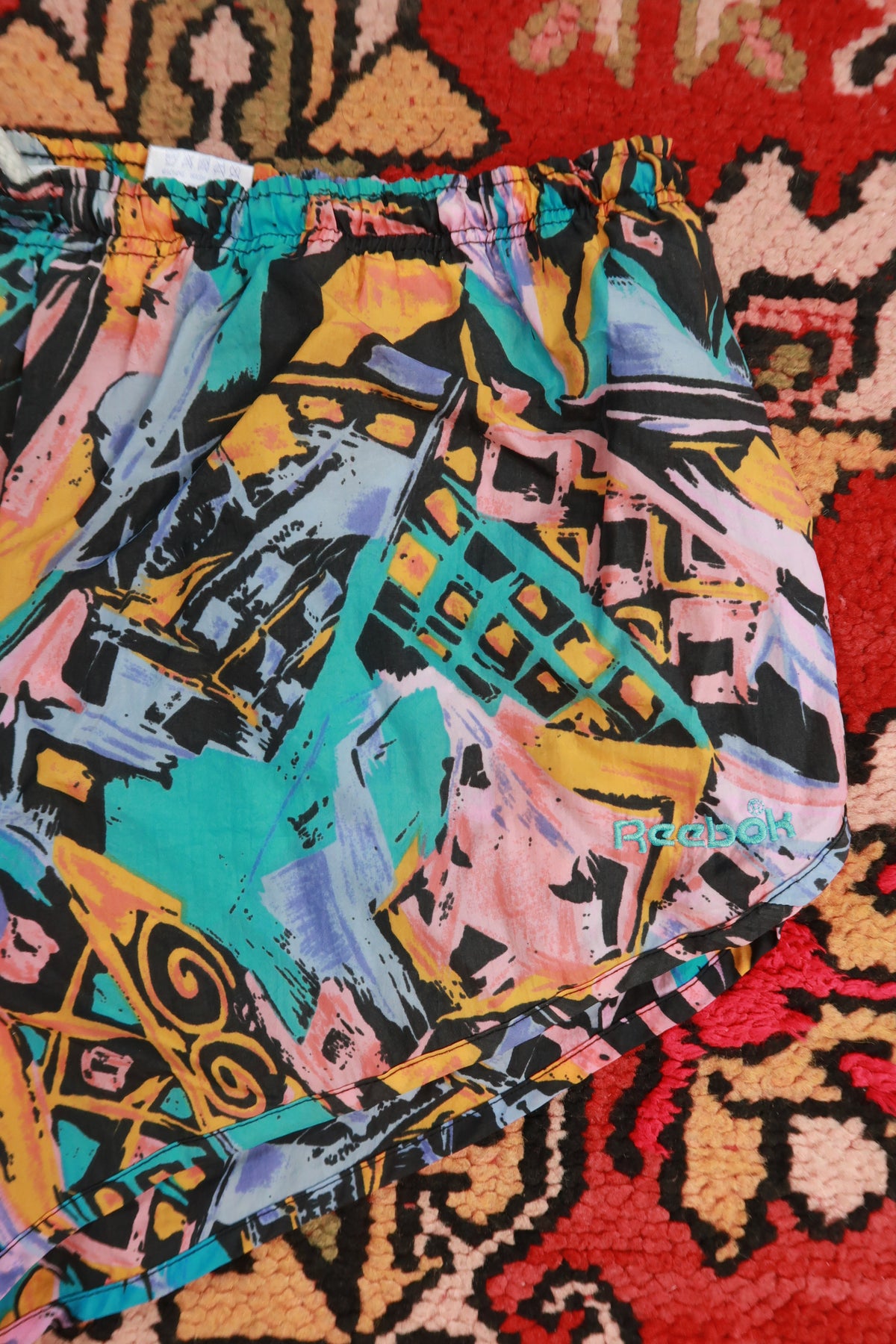 Vintage 90s Reebok women's running shorts with abstract print from Elektra Vintage, featuring a relaxed fit and vibrant design.