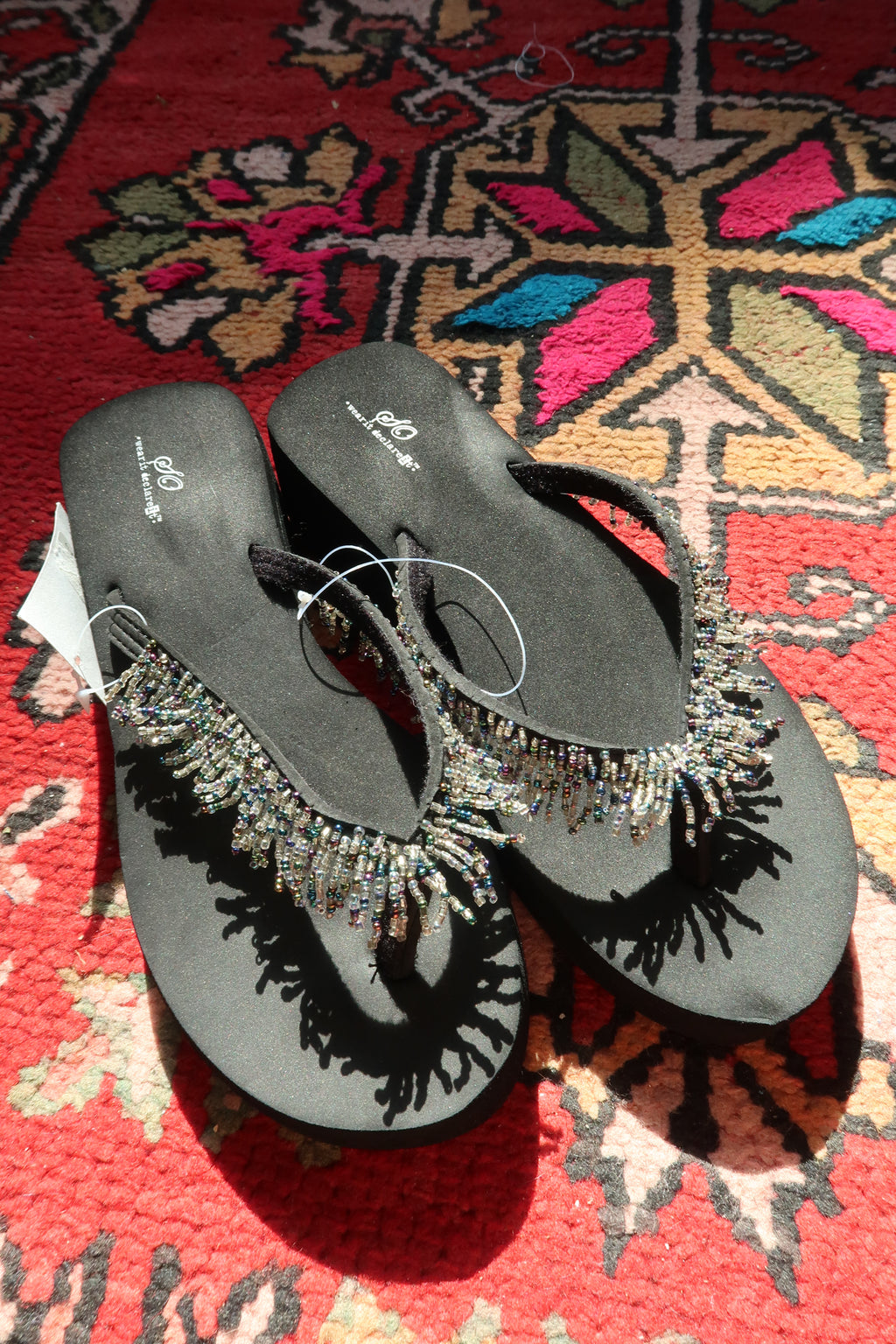 Black Y2K vintage beaded flip flops by Elektra Vintage, featuring colorful bead embellishments and classic slip-on design.