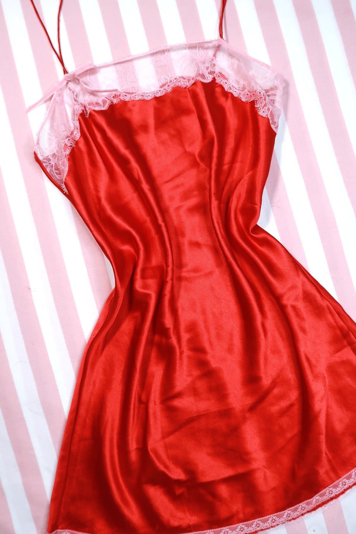 Vintage 2000s Victoria’s Secret red satin slip dress with lace trim, featuring a fitted silhouette and delicate detailing, by Elektra Vintage.