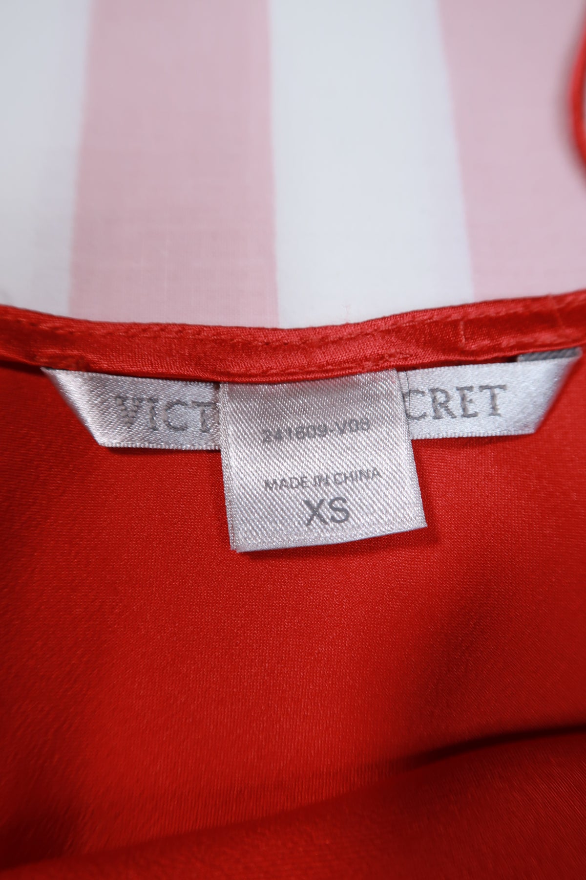 Vintage 2000s Victoria’s Secret red satin slip dress with lace trim, from Elektra Vintage, shown on a hanger.
