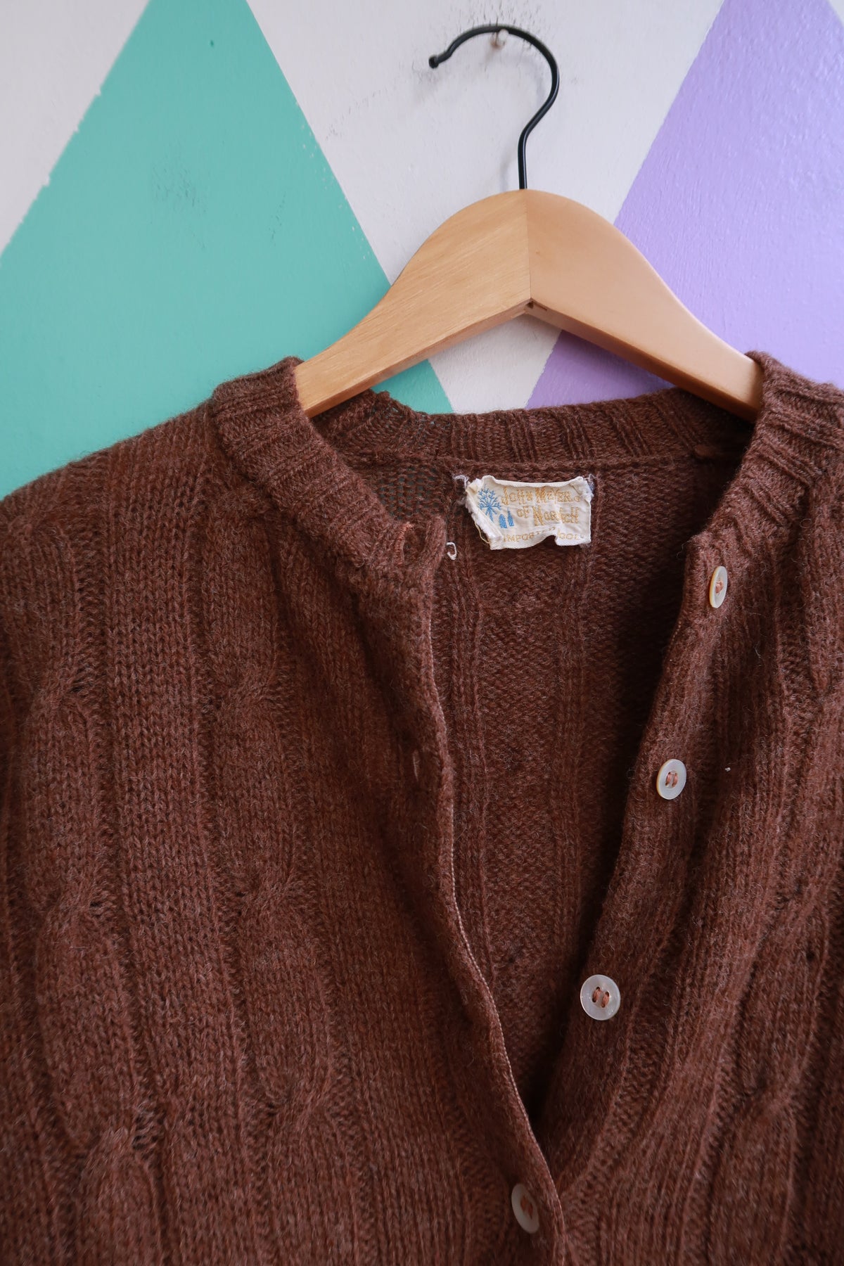 Vintage 1960s John Meyer brown wool button-up cardigan with front pockets, styled on a hanger.