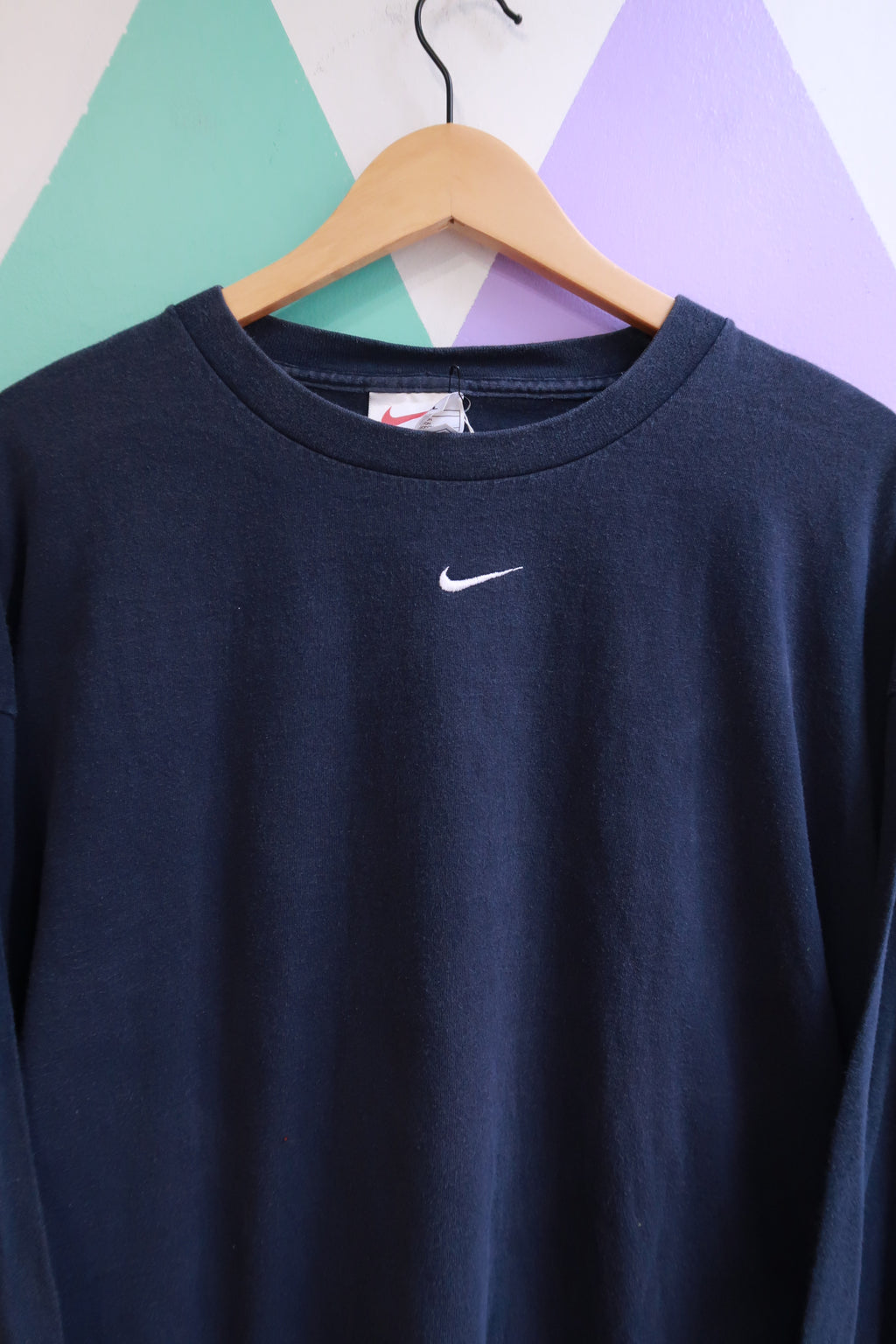 Vintage 2000s Nike navy long sleeve shirt with embroidered swoosh logo, displayed flat on a white background.