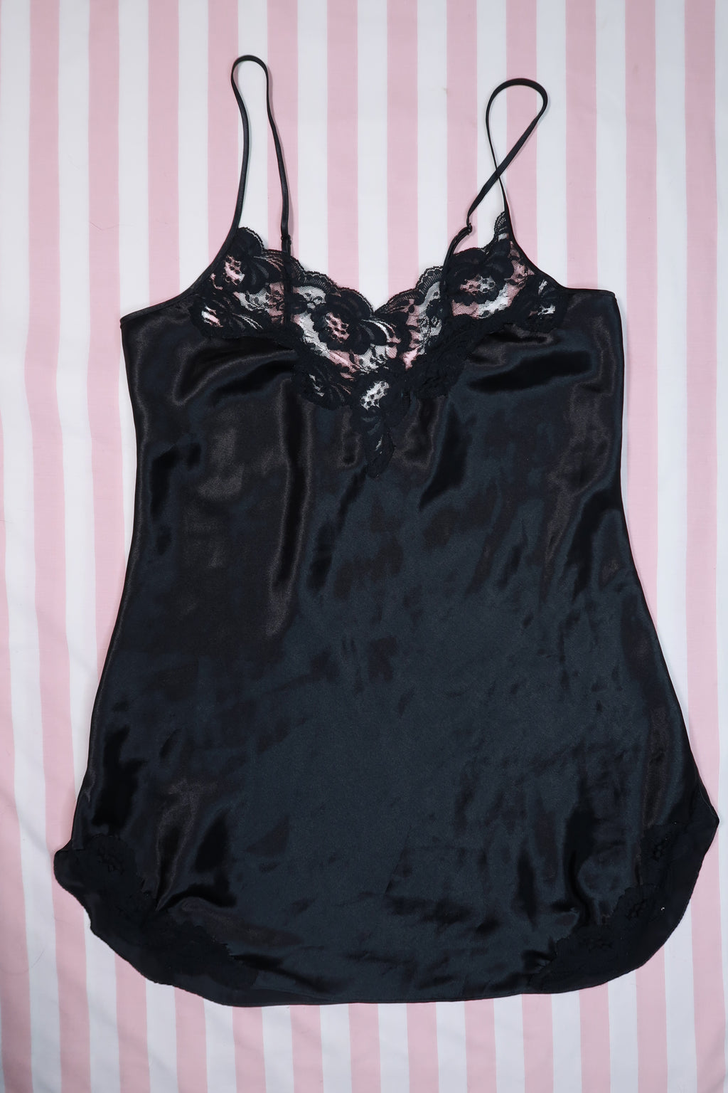 Vintage 80s black satin lace slip dress by Victoria’s Secret, styled with gold label and elegant lace details, on a hanger.
