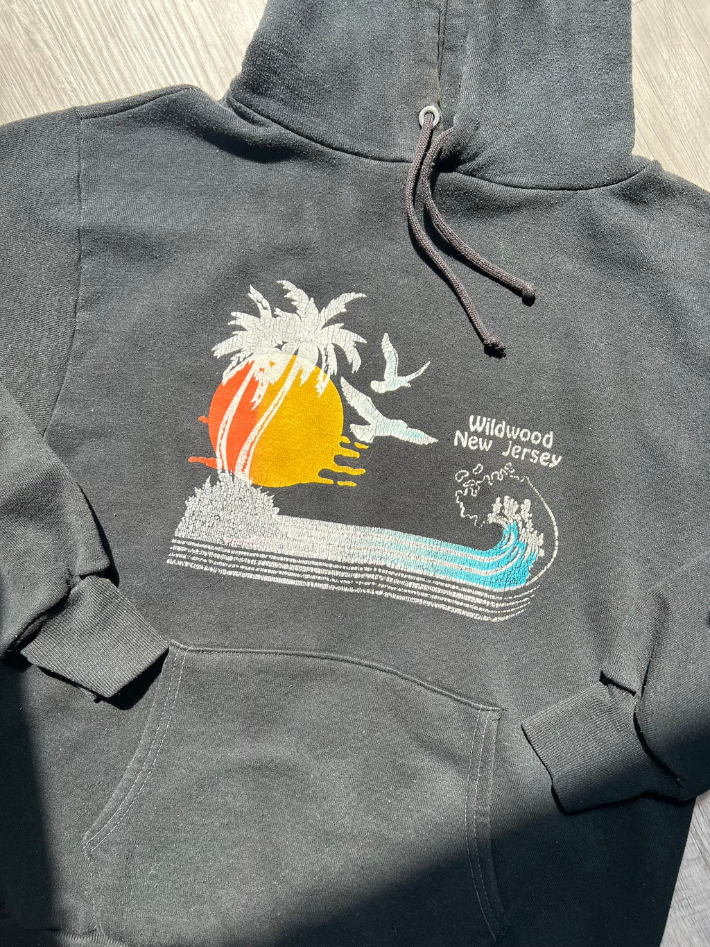 Black 80s Vintage Wildwood New Jersey hoodie by Russell, featuring retro style and classic branding, styled on a hanger.