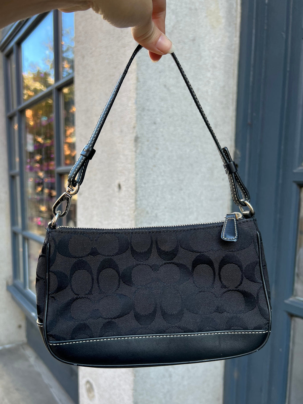 Vintage black Coach Signature C Demi Shoulder Bag with gold-tone hardware and adjustable strap, displayed against a neutral background.