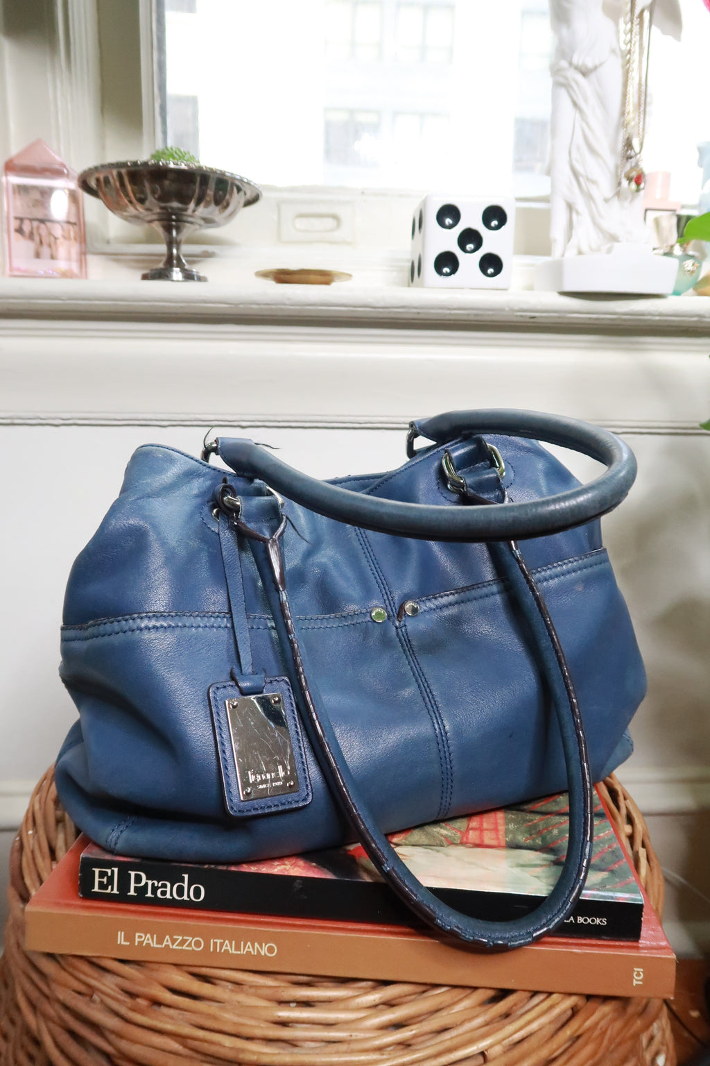 Vintage Tignanello blue genuine leather shoulder bag by Elektra Vintage, showing the textured leather surface and shoulder strap.
