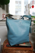 Vintage Coach 19889 blue leather Legacy tassel bag with gold hardware, featuring a classic design and structured silhouette.