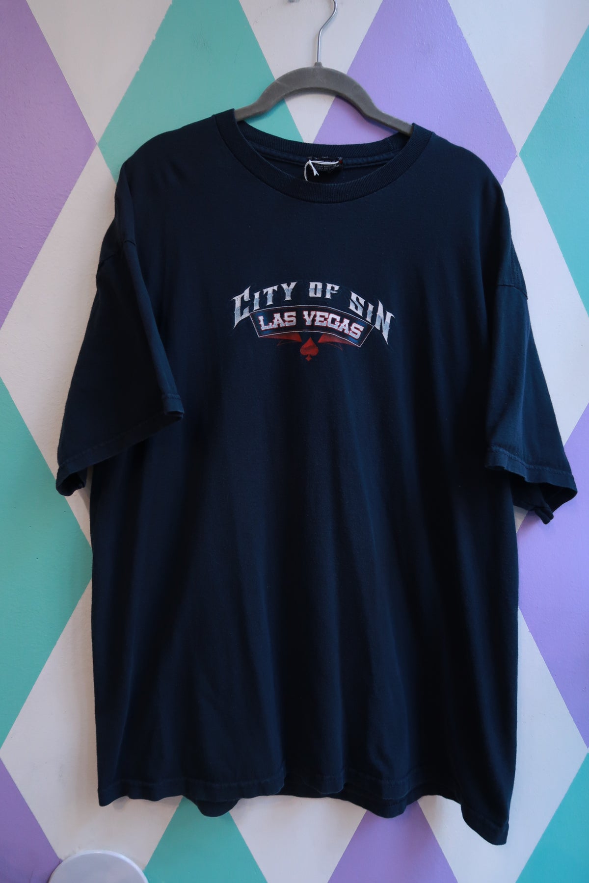 Black men's graphic T-shirt by Elektra Vintage featuring a vintage 2000s Las Vegas City of Sin casino pin-up design.
