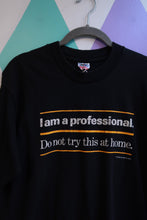 Load image into Gallery viewer, Black vintage graphic T-shirt for men by Elektra Vintage featuring "I Am a Professional. Do Not Try This at Home." slogan.
