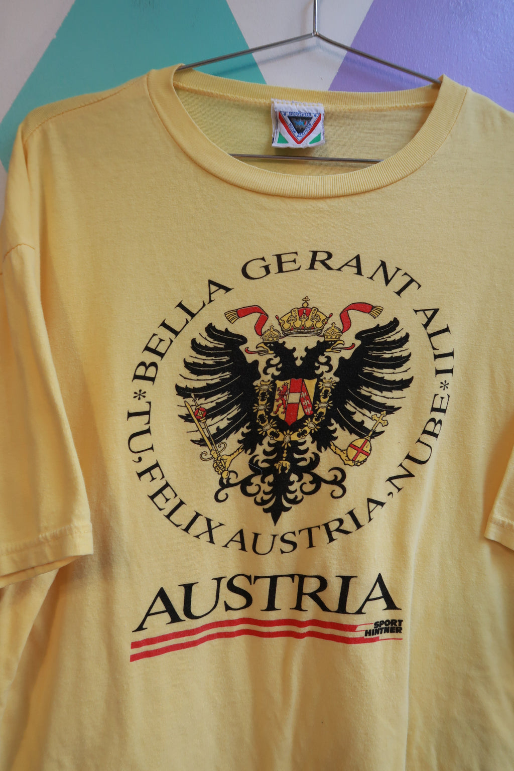 Yellow vintage men's T-shirt featuring Austria crest and eagle graphic, by Elektra Vintage, with travel souvenir design.