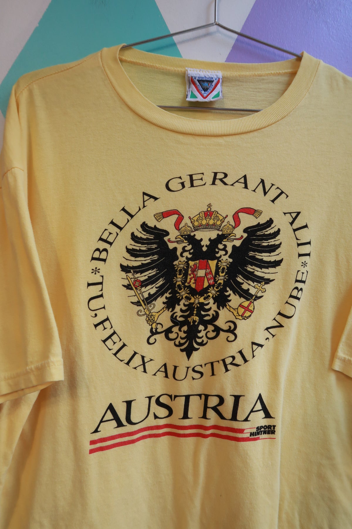Yellow vintage men's T-shirt featuring Austria crest and eagle graphic, by Elektra Vintage, with travel souvenir design.