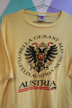 Load image into Gallery viewer, Yellow vintage men's T-shirt featuring Austria crest and eagle graphic, by Elektra Vintage, with travel souvenir design.
