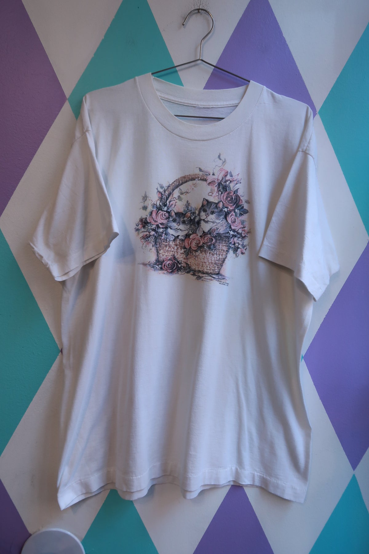 White men's T-shirt by Elektra Vintage featuring vintage cottagecore kitten in basket floral graphic design.