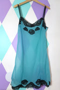 Elegant vintage sheer blue slip dress with black lace details, styled by Elektra Vintage. Light, flowing fabric with delicate lace accents.