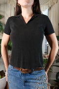 Vintage black knit collared short sleeve top for women by Elektra Vintage, shown on a hanger with detailed knit fabric.