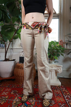 Load image into Gallery viewer, Women's vintage 2000s khaki low rise flare pants with printed scarf belt from Elektra Vintage, styled with classic denim and retro accessories.
