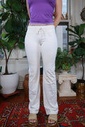 Elektra Vintage women's white low-rise flare pants with vintage Y2K style, shown on a hanger against a plain background.