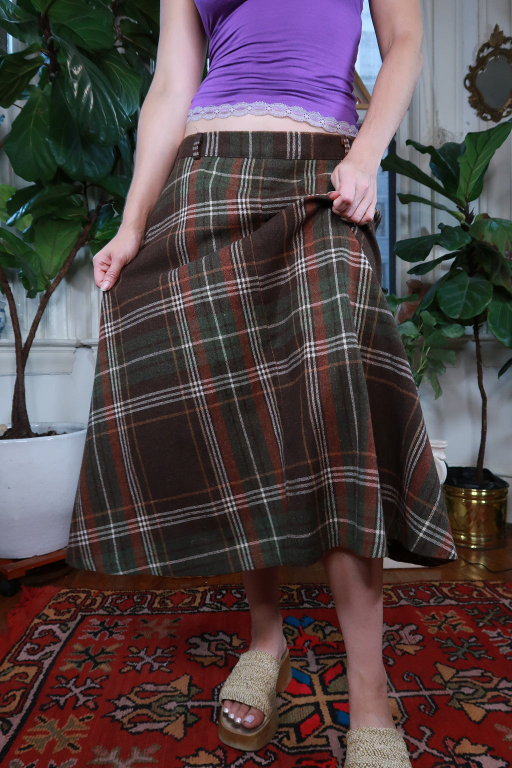 Vintage brown and green plaid midi skirt by Elektra Vintage, showcasing classic pattern and flowing fabric.