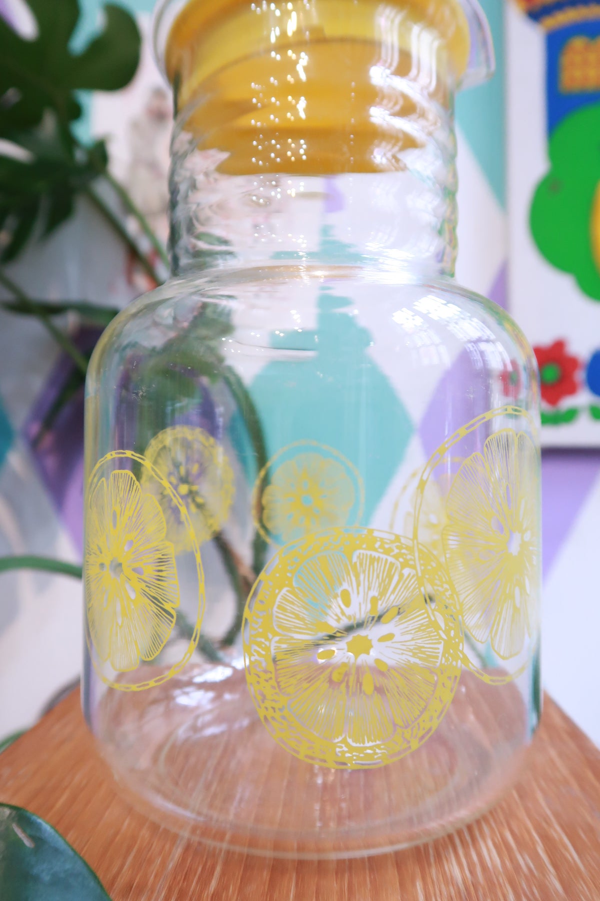 Vintage lemon print glass pitcher with yellow lid by Elektra Vintage, featuring retro citrus design for serving juice.