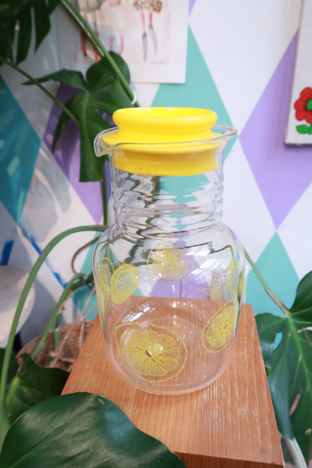 Vintage lemon print glass pitcher with yellow lid by Elektra Vintage, designed for serving citrus juice in a retro style.