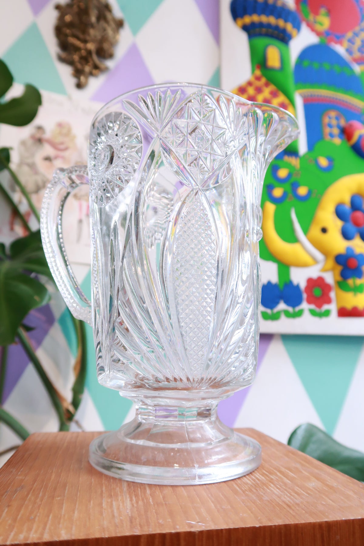 Vintage pressed cut glass pitcher by Elektra Vintage with starburst and fan pattern, pedestal water pitcher with intricate design.