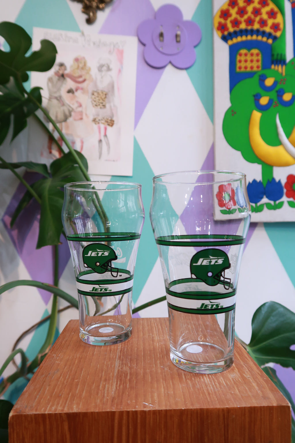 Set of two vintage New York Jets pint glasses featuring retro NFL Jets helmet designs, ideal for display or drinking.
