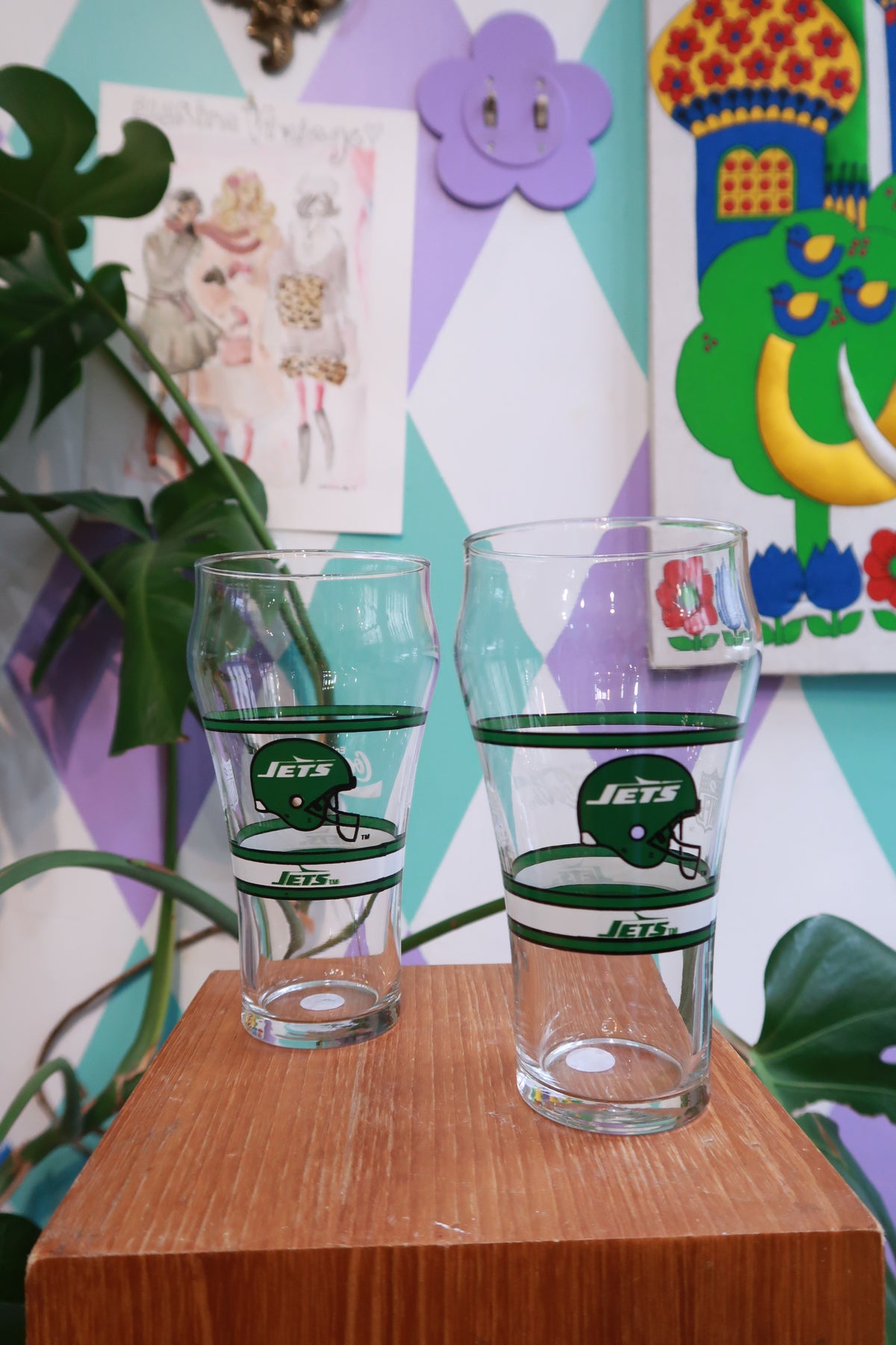Set of two vintage New York Jets pint glasses featuring retro NFL Jets helmet designs, ideal for display or drinking.