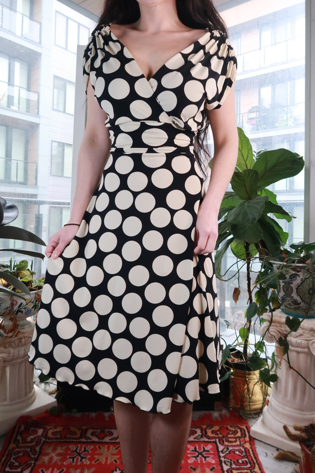 Vintage black and white polka dot wrap dress by Elektra Vintage, Y2K fit and flare midi style, shown on a hanger.