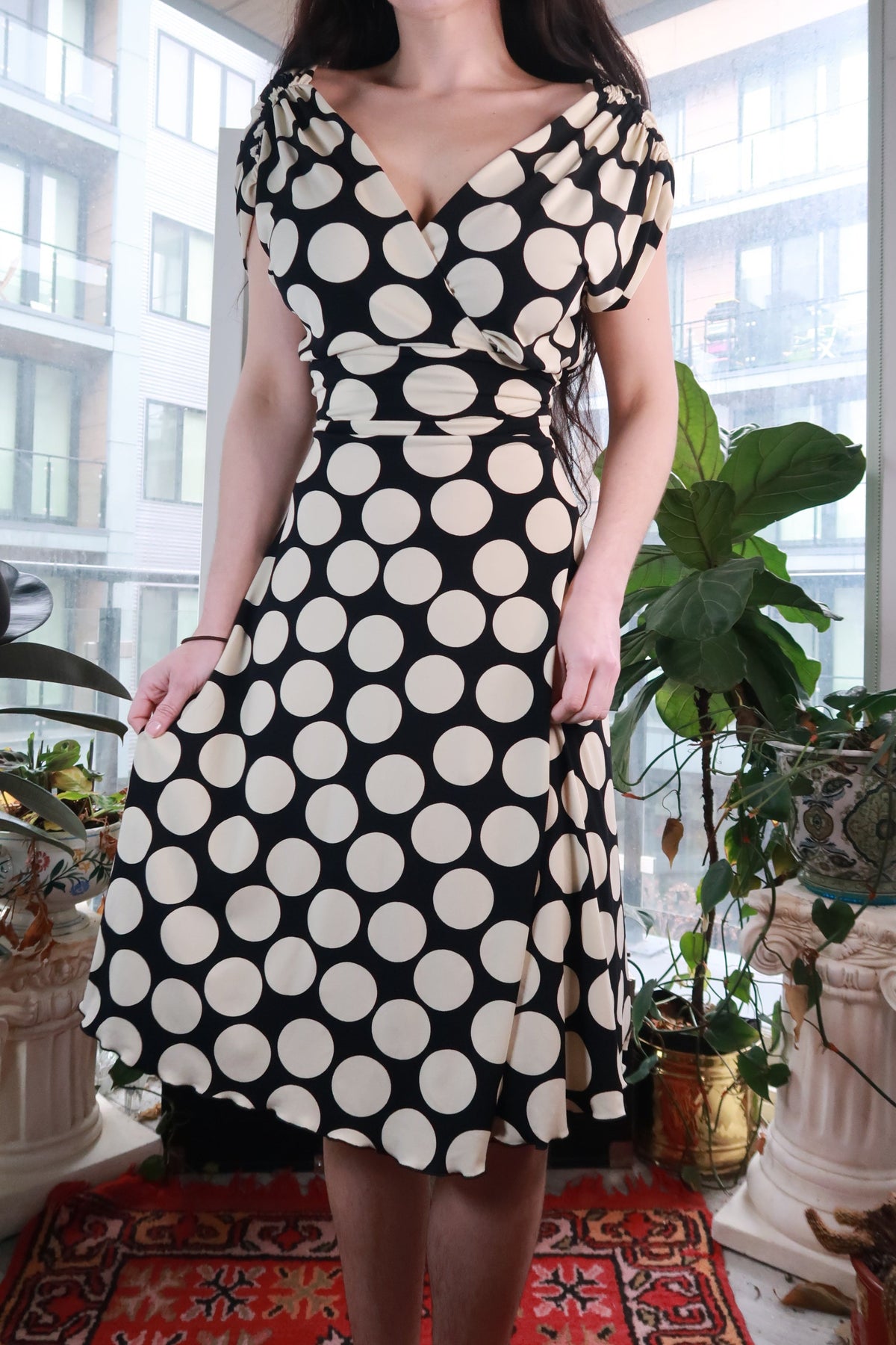 Vintage black and white polka dot wrap dress by Elektra Vintage, Y2K fit and flare midi style, shown on a hanger.