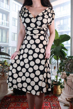 Load image into Gallery viewer, Vintage black and white polka dot wrap dress by Elektra Vintage, Y2K fit and flare midi style, shown on a hanger.
