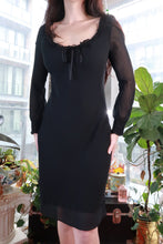Load image into Gallery viewer, Black silk dress by Elektra Vintage featuring sheer sleeves, romantic ruffle neckline, tie-front, mini length, vintage-inspired style.
