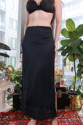 Black satin maxi skirt with lace trim and side slit, vintage Elektra Vintage slip skirt styled with elegant detailing.