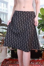 Load image into Gallery viewer, Black ditsy floral midi skirt by Elektra Vintage featuring a flowy A-line silhouette, perfect for vintage and Y2K fashion styles.
