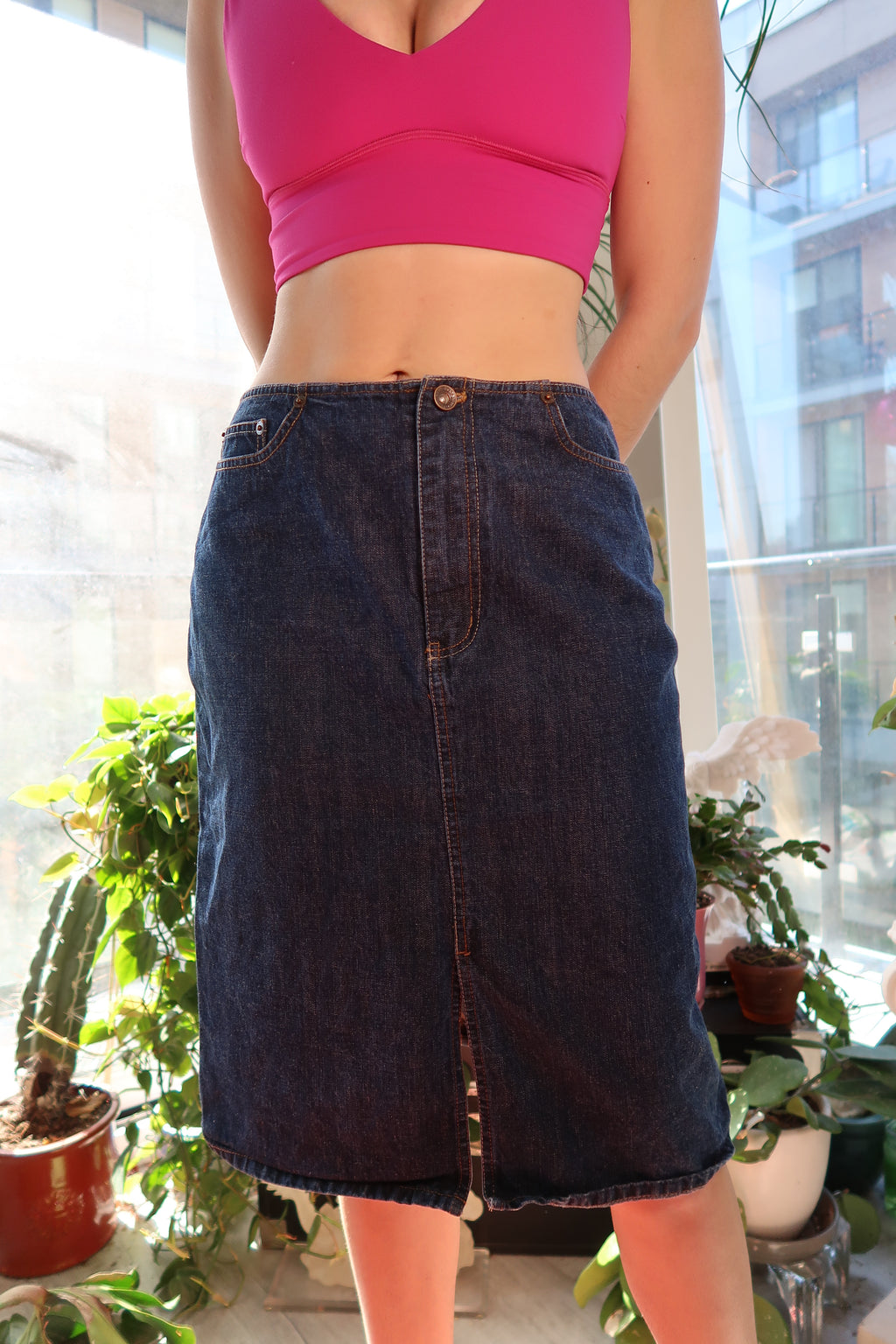 Dark wash denim skirt by DKNY from the 2000s, featuring a vintage style, shown on a hanger.