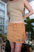 Load image into Gallery viewer, Vintage 2000s orange cargo mini skirt by Elektra Vintage featuring low rise, utility pockets, and a bird graphic design.
