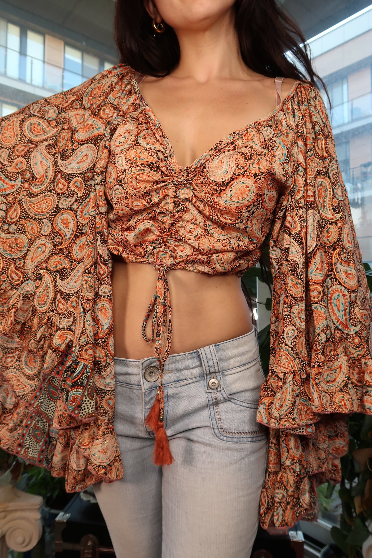 Women's Elektra Vintage Boho paisley crop top with bell sleeves and tassel tie detail on a neutral background.