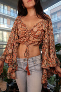 Vintage Y2K Elektra Vintage boho paisley crop top with bell sleeves and tassel tie detail on a white background.