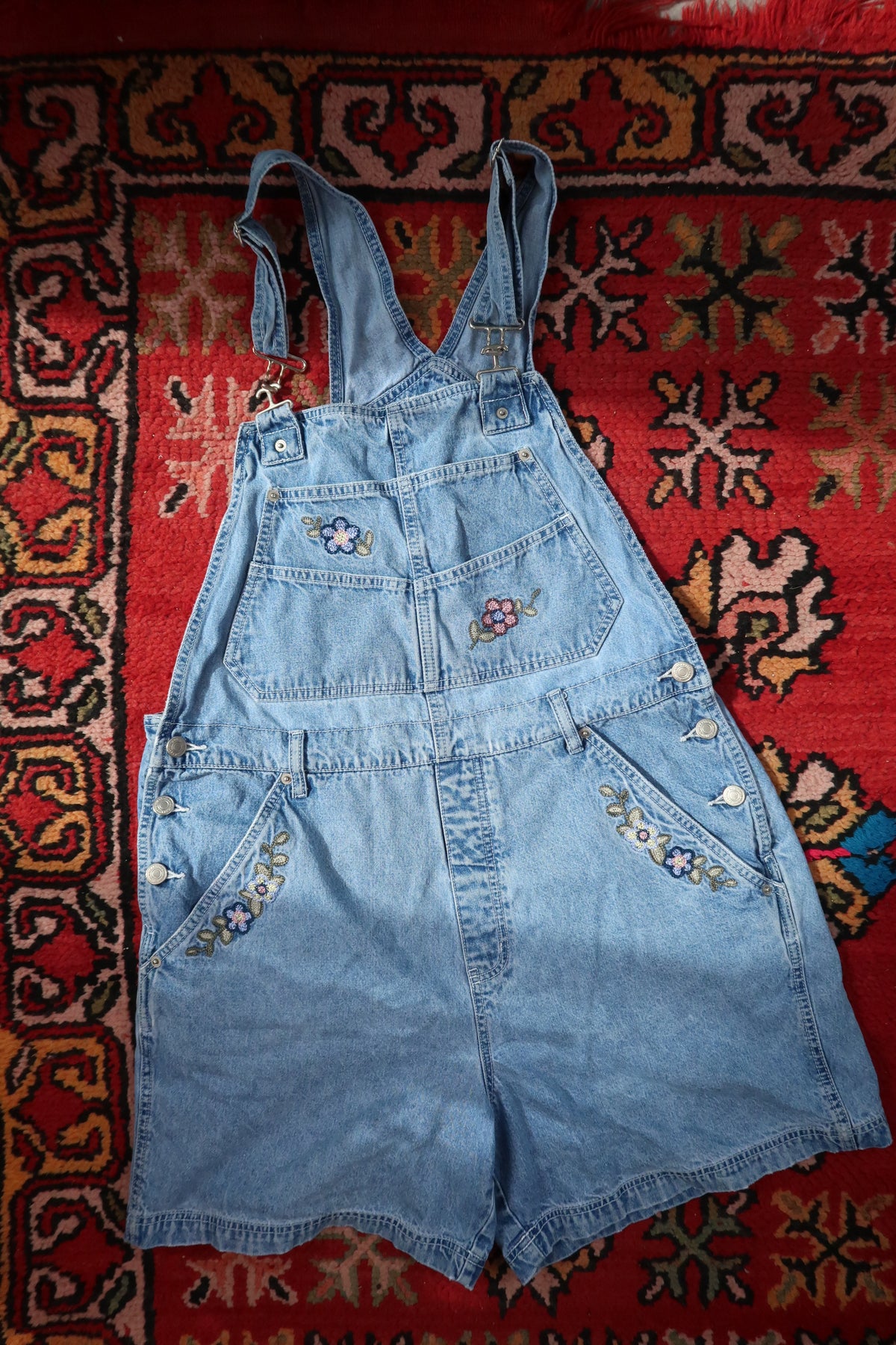 Vintage 1990s denim embroidered overall shorts dress by Elektra Vintage, featuring colorful floral embroidery and a casual fit.