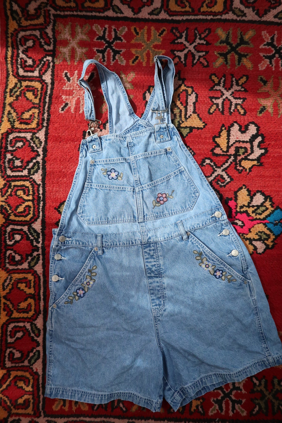 Vintage 1990s denim embroidered overall shorts dress by Elektra Vintage, showing detailed embroidery and classic denim fabric.