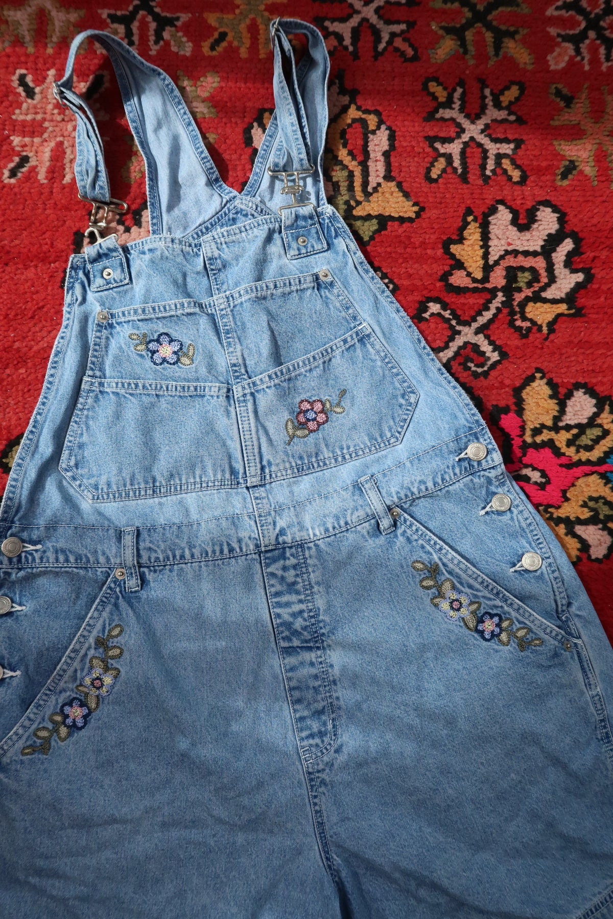 Vintage 1990s denim embroidered overall shorts dress by Elektra Vintage, showcasing detailed embroidery and classic denim fabric.