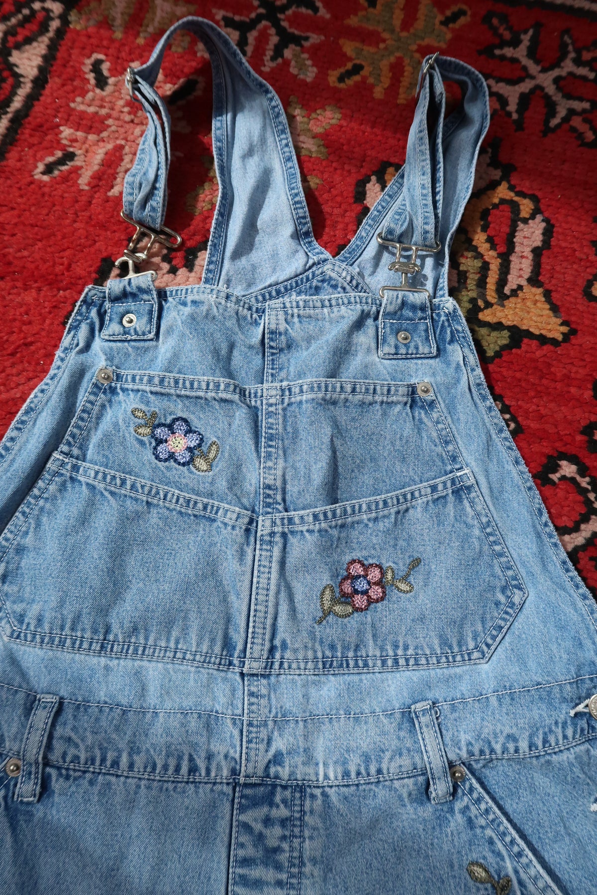 Vintage 1990s denim embroidered overall shorts dress by Elektra Vintage, featuring colorful embroidery and classic denim fabric.