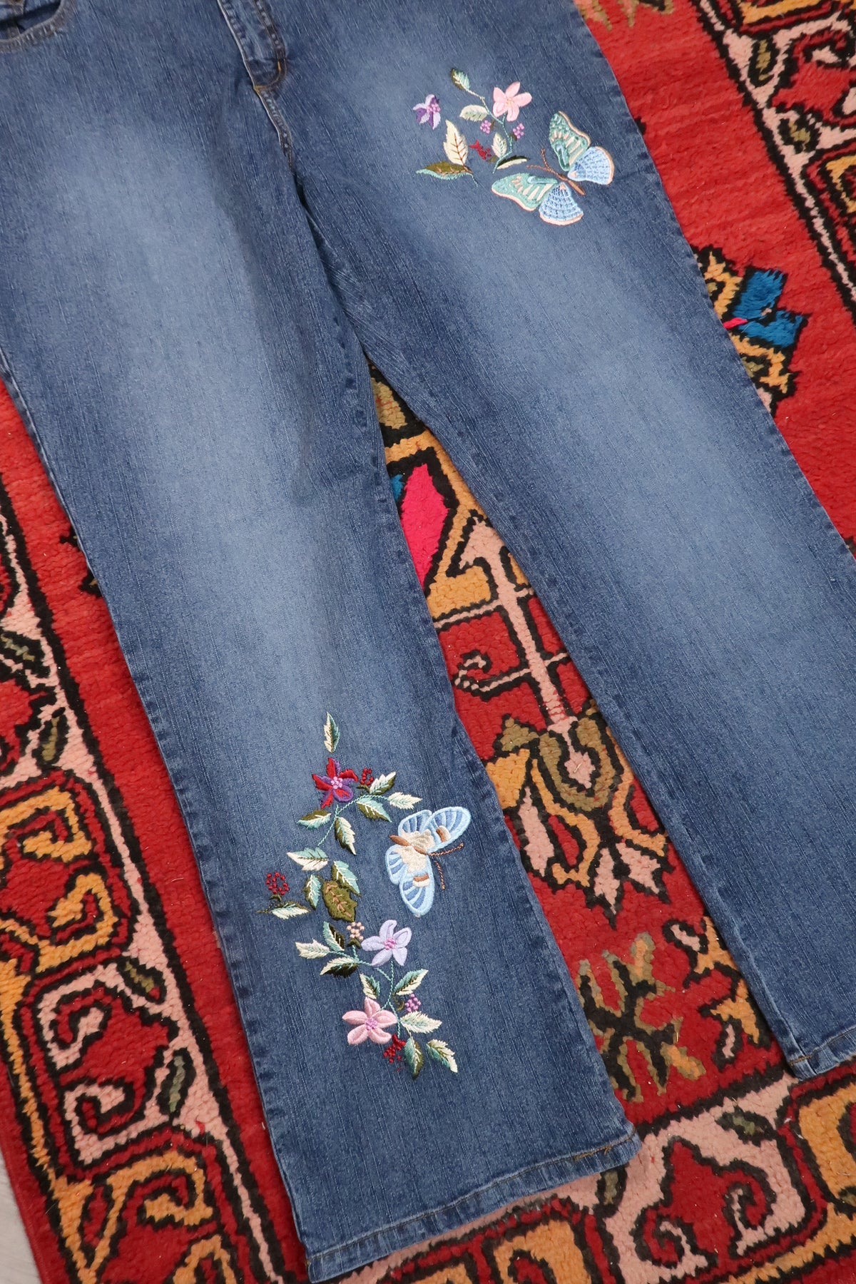 Women's vintage denim jeans with butterfly embroidery from the 2000s by Elektra Vintage, featuring classic distressed details.