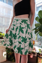 Load image into Gallery viewer, Vintage 2000s green floral A-line mini skirt by Elektra Vintage, featuring white and emerald green Y2K-inspired design.
